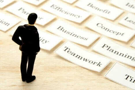 Professional toy figure on table looking at business keywords